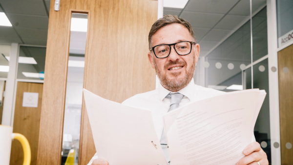 Man at desk reading. Book a premium consultation